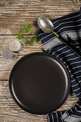 Black plate, spoon and napkin.