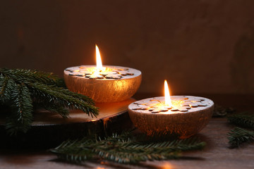 Christmas decoration, Silver candles burning on table decorated with fir branches..