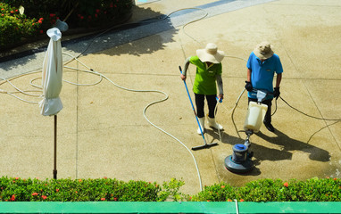 Hotel staff, cleans the area with an electric floor-polisher and detergents, from dirt and miscellaneous debris	