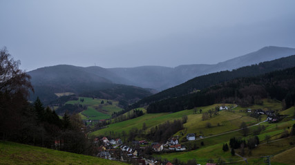 Fototapeta na wymiar Germany, Aerial view above pretty little black forest village early morning with rain and fog in winter