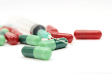 Green capsules red capsules and a syringe isolated