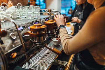 Barista making coffee from espresso machine in coffee shop