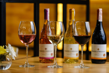 glass of red wine and bottle of wine on wooden table