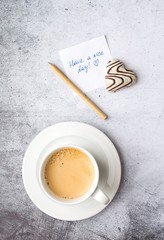 A declaration of love, zero waste pen, heart gingerbread, coffee mug on a gray background. Top view, vertical format