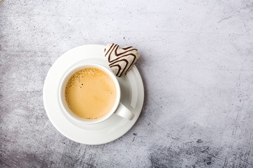 Coffee mug with carrot in the shape of a heart on a gray background.