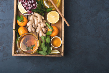 Fototapeta na wymiar Health and diet content. Natural immune system support kit-ginger, lemon, frozen cranberries, mint tea, turmeric, tangerines. Ascorbic acid. Top view.