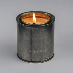 Burning candle in a metal can.