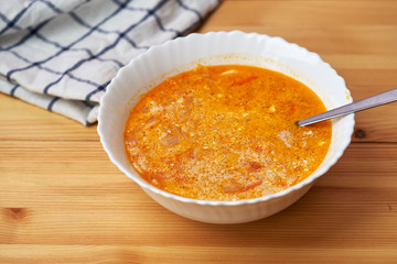 plate with traditional borscht (beetroot soup) on wooden table.