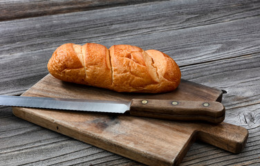 Organic whole wheat loaf with curated knife on cutting board in close up layout
