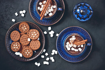 Hot chocolate drink with spices on dark background