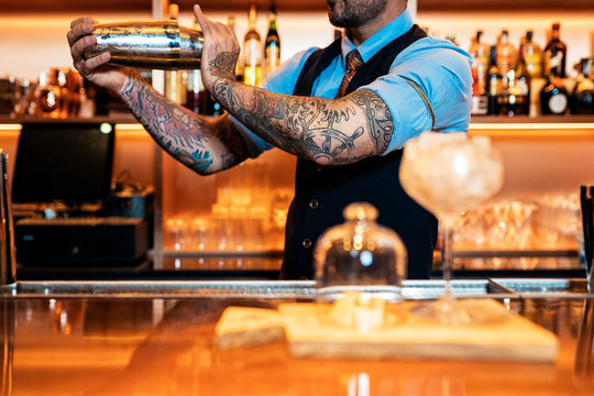 Unrecognizable professional young bartender working