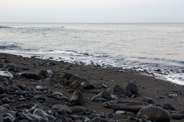 Black lava stones in the surf