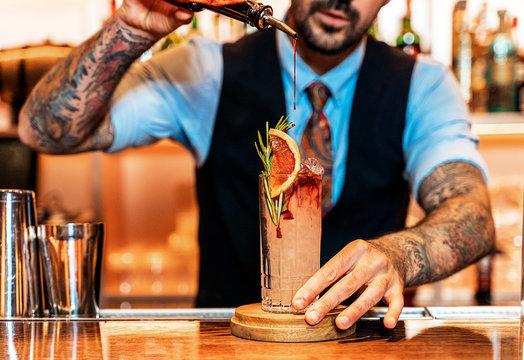 Unrecognizable professional young bartender working