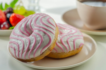 Doughnut with raspberry flavour filling, topped with white and pink icing