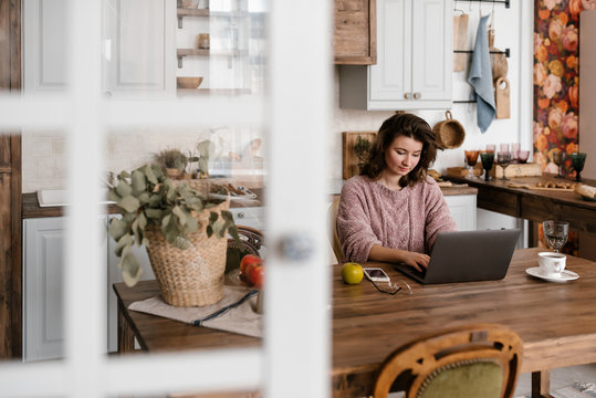 Female freelancer using laptop in kitchen