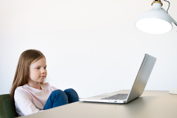 Cute little girl smiling and looking at laptop,Little girl using laptop