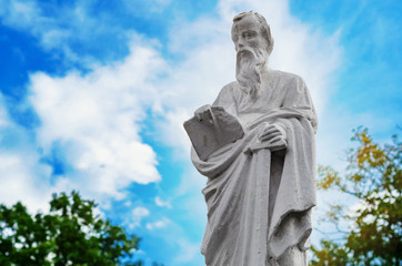Fototapeta na wymiar Ancient christian statue on blue sky background