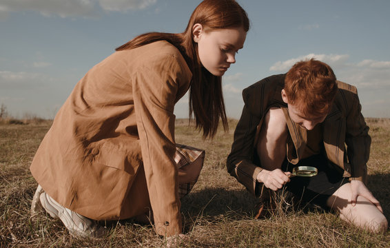 Twins examining ground in field