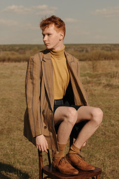 Retro guy sitting on chair in field