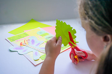 Caucasian girl cutting with red scissor: metamorphosis craft