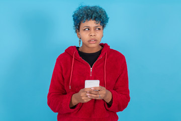 young woman with mobile phone isolated on blue background with space for text