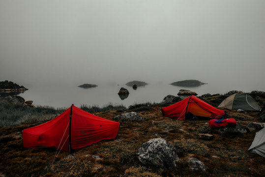 Camping tents on coast in thick fog