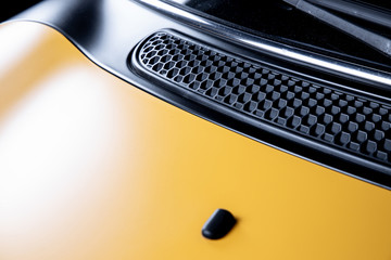 Motorhaube von einem gelb schwarzen sport wagen mit matter Lackierung, Motorsport oder schnelle Autos