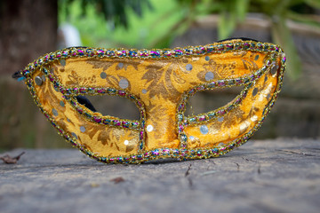 Carnival mask from Brazil, resting on a wooden board