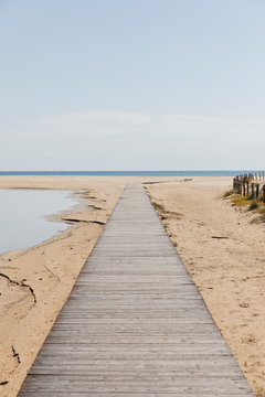 Wooden walkway on the beach that goes towards the sea