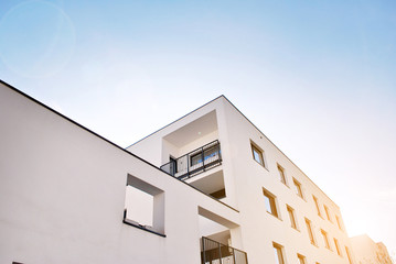 Sun rays light effects on urban buildings. Fragment of modern residential apartment with flat buildings exterior. Detail of new luxury house and home complex. 