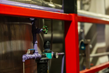 violet metal pipe with industrial valves selective focus close up view, modern brewhouse brewery beer factory interior view