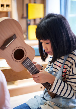 Asian children are learning to make ukulele in vacation