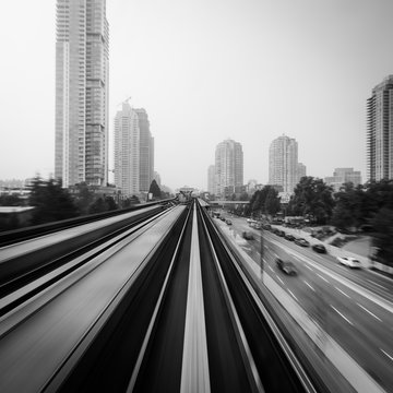 A long exposure from the front of a subway train moving towards a built up area