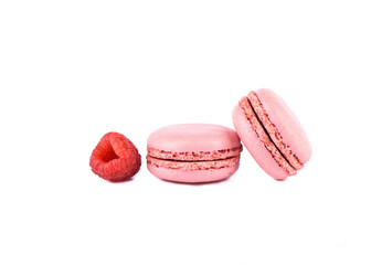 Two pink macaroon and raspberry isolated on a white background.