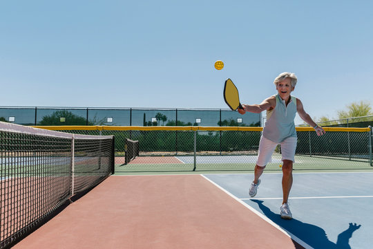 Senior Woman Playing Pickleball on Court