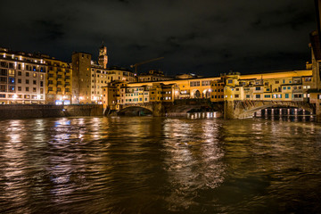 Fototapeta na wymiar Vista nocturna del río Arno y el Ponte Vecchio en la ciudad medioeval y cuna del Renacimiento de Florencia, Italia.