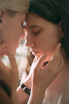 tender portrait of two lesbian faces close in warm light