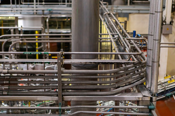 a complicated piping system, hot water metallic pipes with wires, packaging area, belt conveyor...