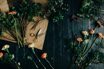 Working table with flowers and florist props on it seen from above