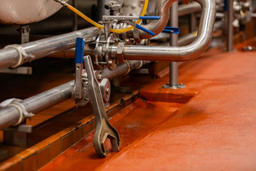 stainless steel metallic pipes and fittings selective focus, Centric Semi Lug wafer type butterfly valves and an industrial big wrench