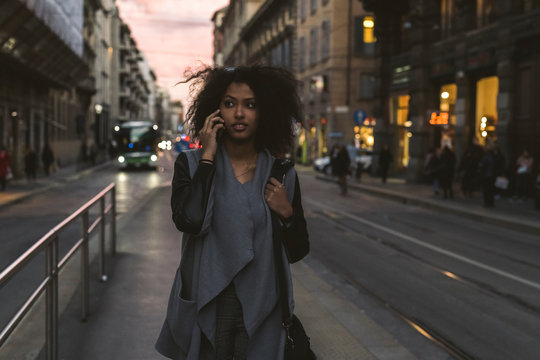 Woman talking on the phone in the city at twilight