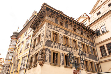 Obraz premium The architecture of the old city of Prague. The ancient building is painted with figures of people.