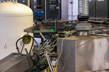 Various electrical components of Conveyor belt system for beer cans in a modern brewhouse brewery factory with industrial machines