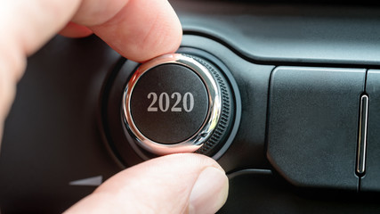Man turning a dial or electronic control knob with the date 2020 on the top