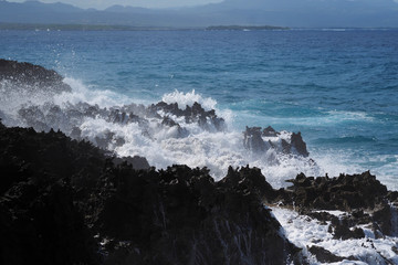 Seascape Breaking Waves on Black Lava Rock. Coastline with turquoise wave breaking on lava rock