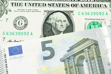 A close up image of a one American dollar note close up in macro with blue and green five euro bank note from the European Union and the European Central Bank
