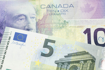 A close up macro shot of a purple ten Canadian dollar bill with a five Euro note