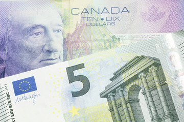 A close up macro shot of a purple ten Canadian dollar bill with a five Euro note