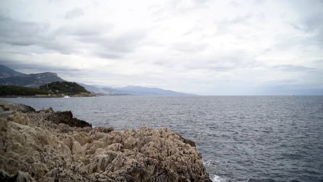 Panoramic view of nice colorful huge cliff and sea. Action. View of the rocks and waves of the sea