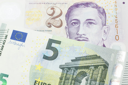 A close up image of a fve euro bank note from the European Central bank and the European Union in macro with a two dollar bill from Singapore